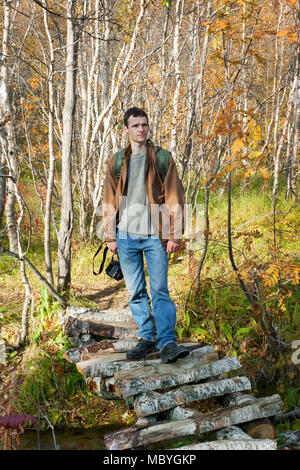 Tourist on a bridge over creek In the autumn Stock Photo