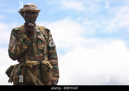 A Zambian soldier monitors radio chatter during ZAMBAT IV at the Nanking Peace Mission Training Center, Lusaka, Zambia, March 26, 2018. Training modules included: marksmanship, mounted battle drills, training alongside Indian Army counterparts for battlefield trauma, cordon and search, and convoy operations with British soldiers. Zambian infantrymen rehearsed tactics and real-world scenarios likely to be encountered while serving in support of the United Nations Multidimensional Stabilization mission in the Central African Republic (MINUSCA). Stock Photo