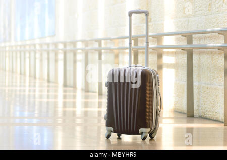 Packed travel suitcase, airport. Summer holiday and vacation concept. Traveler baggage, brown luggage in empty hall interior. Copy space Stock Photo
