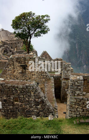 UNESCO World Heritage Site Machu Picchu on top of a Mountain Ridge above the Sacred Valley within the Rainforest in the Andes Mountain Range in Peru Stock Photo