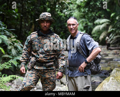 U.S. Air Force Chief Master Sgt. Scott Robbins, 346th Air Expeditionary Group superintendent, stands for a photo with a member of the Panamanian military and police force known as SENAFRONT, while hiking in the Darien National Park, Panama, April 2, 2018, during exercise New Horizons 2018. Exercise New Horizons is a joint training exercise where all branches of the U.S. military conduct training in civil engineer, medical and support services while benefiting the local community. Stock Photo