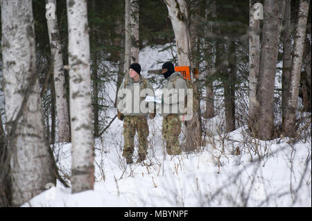 Paratroopers assigned to the 4th Infantry Brigade Combat Team (Airborne), 25th Infantry Division, U.S. Army Alaska, conduct a land navigation course on Joint Base Elmendorf-Richardson, Alaska, April 4, 2018.  The Soldiers used their skills to plot courses using a lensatic compass, protractor, and a 1:25,000 scale map to navigate to, and locate points using provided grid coordinates within a predetermined time. Stock Photo