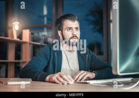 Earnest IT guy checking code Stock Photo