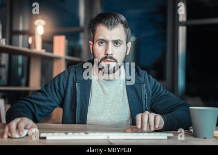 Uneasy IT guy developing software Stock Photo