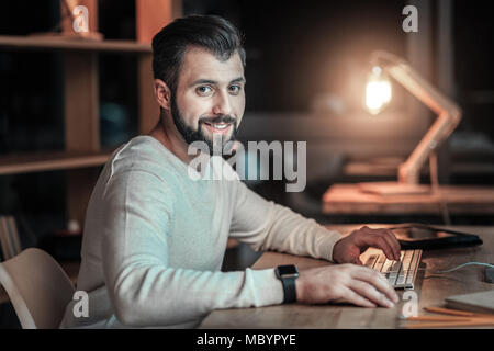 Positive IT guy writing computer software Stock Photo
