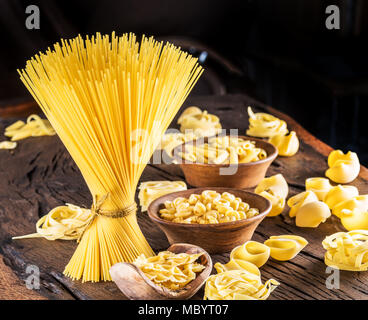 Different pasta types on wooden table. Stock Photo