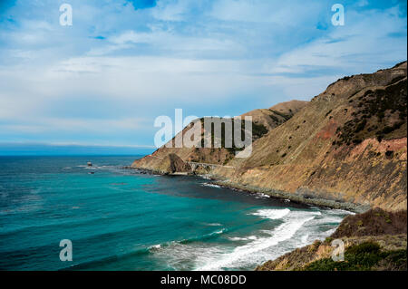 Pacific coast views along Cabrillo Highway to Big Creek Cove bridge, California. Beautiful landscape, cloudy skies, rocky cliffs and aquamarine sea. Stock Photo