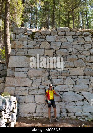 WASHINGTON - Cyclist standing in front of the mass structure known at the Chinese Wall built then abandoned by the Arlington Mining Company. Stock Photo