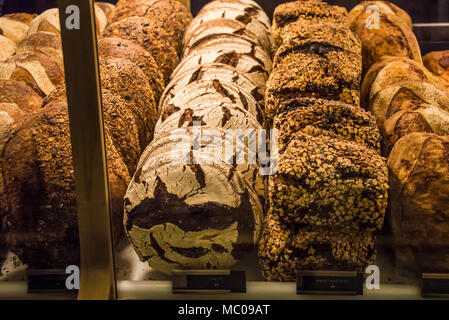 Variety of wholegrain breads arranged at a bakery window. Stock Photo
