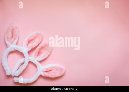 Top view of two white fluffy bunny ears over pink background. Easter concept. Copy space. Stock Photo