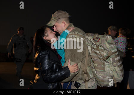 Staff Sgt. Justin Stevenson, 436th Security Forces Squadron defender, kisses his wife, Jamielee, while hugging his daughter, Julia, upon his return home from deployment to the Middle East Jan. 21, 2018, at Dover Air Force Base, Del. Stevenson’s team has been deployed since July 2017. (U.S. Air Force Photo by Staff Sgt. Aaron J. Jenne) Stock Photo