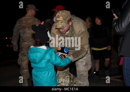 Staff Sgt. Justin Stevenson, 436th Security Forces Squadron defender, hands a stuffed animal to his daughter, Julia, Jan. 21, 2018, at Dover Air Force Base, Del. Stevenson and 11 of his wingmen returned early that morning from a six-month deployment to the Middle East. (U.S. Air Force Photo by Staff Sgt. Aaron J. Jenne) Stock Photo