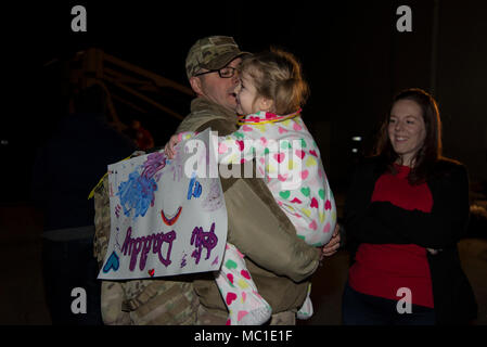 Master Sgt. Michael Johnson, 436th Security Forces Squadron defender, hugs his daughter, Amelia, as his wife, Kelly, looks on Jan. 21, 2018, at Dover Air Force Base, Del. The Johnson family was reunited after a six-month deployment to the Middle East. (U.S. Air Force Photo by Staff Sgt. Aaron J. Jenne) Stock Photo
