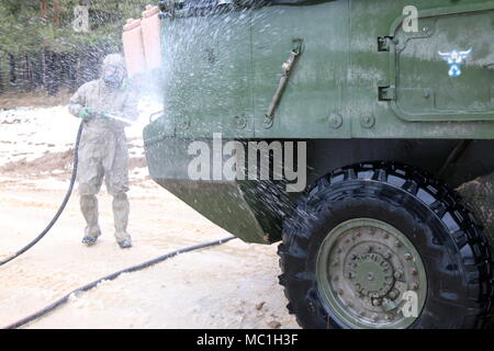 A Polish Soldier decontaminates a Stryker armored combat vehicle from 82nd Engineer Battalion, 2nd Armored Brigade Combat Team, 1st Infantry Division, at the vehicle decontamination site as the unit practices chemical, biological, radiological, nuclear and explosive response operations in preparation for Allied Spirit VIII Jan. 22, 2018 in Hohenfels, Germany. Allied Spirit VIII is designed to provide multinational interoperability training at brigade and battalion levels to enhance U.S. and NATO effectiveness.  (U.S. Army photo by Staff Sgt. Wallace Bonner) Stock Photo