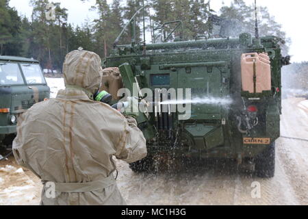 A Polish Soldier decontaminates a Stryker armored combat vehicle from 82nd Engineer Battalion, 2nd Armored Brigade Combat Team, 1st Infantry Division, at the vehicle decontamination site as the unit practices chemical, biological, radiological, nuclear and explosive response operations in preparation for Allied Spirit VIII Jan. 22, 2018 in Hohenfels, Germany. Allied Spirit VIII is designed to provide multinational interoperability training at brigade and battalion levels to enhance U.S. and NATO effectiveness.  (U.S. Army photo by Staff Sgt. Wallace Bonner) Stock Photo