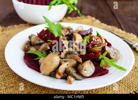 Vegetarian diet Vitamin salad of boiled beets, mushrooms and arugula. Stock Photo