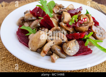 Vegetarian diet Vitamin salad of boiled beets, mushrooms and arugula. Close-up Stock Photo