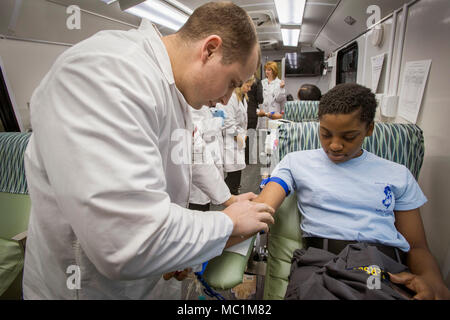 Phlebotomist Kevin Clark, left, Miller Keystone Blood Center, Ewing, N.J.,  inserts a blood donation needle in to Cadet Tatiana Constant's arm during a  blood drive at the New Jersey National Guard Youth