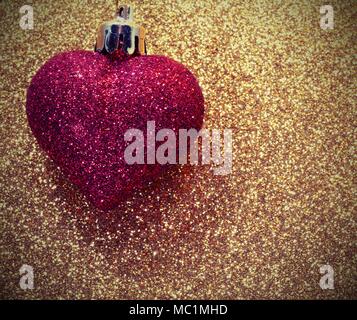 shiny red heart on golden background Stock Photo