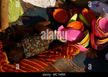 A small child sleeping near the temporary street shop of his poor parents in india Stock Photo
