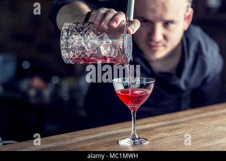 Barman in pub or restaurant  preparing a cocktail drink. Stock Photo