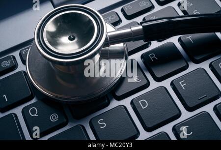 Computer virus concept image. Stethoscope lying on keyboard. Stock Photo