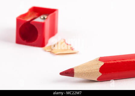 Pencil sharpener and red wooden pencils on white background Stock Photo