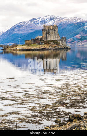 Eilean Donan Castle reflected in Loch Long at high tide, Dornie, Western Highlands, Scotland, UK in March Stock Photo