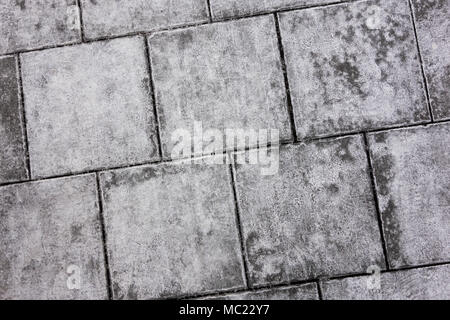 Concrete cobblestoned pavement texture in winter, close-up. Stock Photo