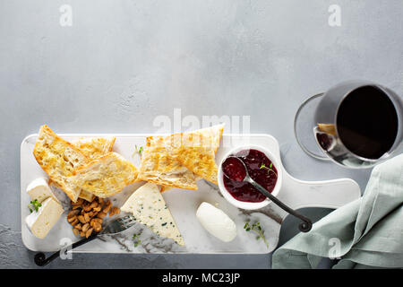 Small cheeseboard with brie, blue cheese, baguette and jam Stock Photo