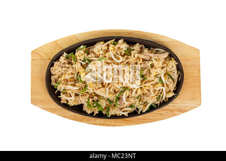 Kao pad rice with chicken, pork, with meat, sprouted soy, green onion, serving in hot frying pan, on wooden board on white isolated background view fr Stock Photo
