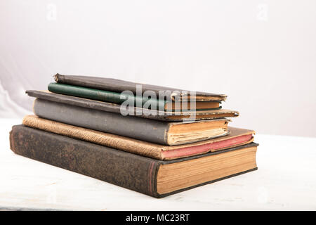 Vintage, antiquarian books pile on wooden surface in studio light. Selective focus. High resolution picture Stock Photo