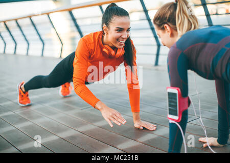 Women doing plank on riverside after running Stock Photo