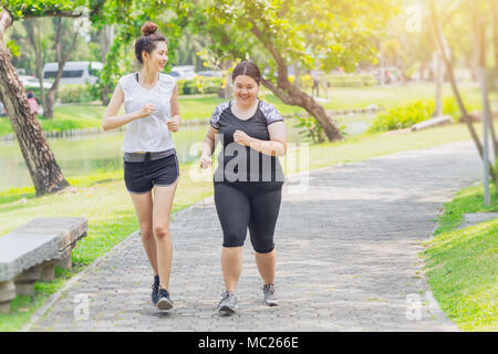 Asian teen running fat and thin friendship jogging in the Park Stock Photo