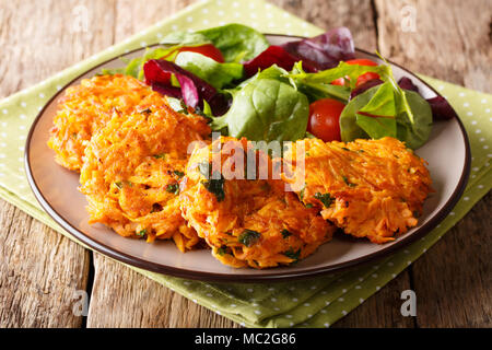 Serving vegetarian crispy pancakes with sweet potato and fresh vegetable salad on a plate close-up. horizontal Stock Photo