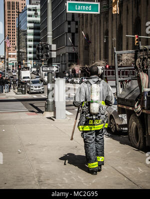 Detroit, Michigan, USA - March 22, 2018: Detroit firefighter walking down a city sidewalk after responding to a call Stock Photo