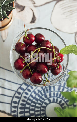 Ecological cherries in glass bowl, on the table, cultivated without pesticides, of manual picking Stock Photo