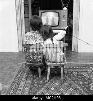 Two young children watch TV before bed-time in the UK, c1967.  Photograph by Tony Henshaw Stock Photo