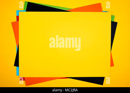 Colorful paper sheets stack on yellow background. Stock Photo