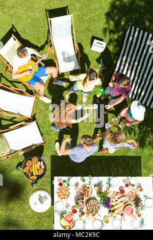 Group of friends having fun at a grill party, listening to music Stock Photo