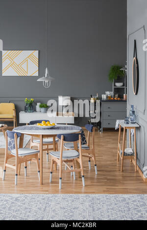 Inspiration for a dark, designer apartment interior with an open living and dining space and scandinavian style wooden furniture Stock Photo