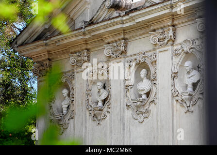 Exterior of a building in the gardens at Villa Borghese. Marble busts line alcoves in a tranquil garden setting. Stock Photo