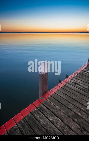 Tranquil water and timber decking at dawn or dusk Stock Photo