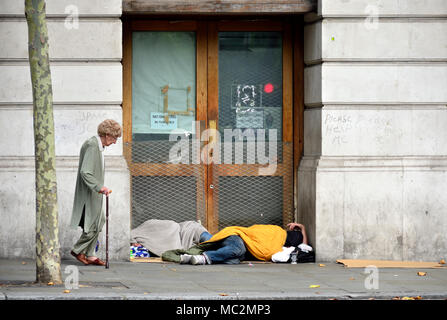 London, England, UK. Two homeless people sleeping in a doorway in St Martin's Place, near Trafalgar Square Stock Photo
