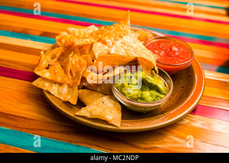 chips nachos on a plate with spices from Mexican cuisine with sauces on the table Stock Photo