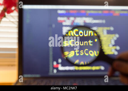 PHP back-end code zoomed through a magnifier. Computer programming source code lookup. Abstract screen of web developer. Code is created by myself. Stock Photo