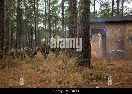 Marines in an Assaultman Course with the Infantry Training Battalion, School of Infantry East, detonate an explosive at ETA-8A engineer demolition training range and urban breaching facility on Marine Corps Base Camp Lejeune, N.C., Jan. 12, 2018. The exercise was held to demonstrate different demolition and explosive breaching training techniques, and to develop proficiency in mobility support for infantry units. (U.S. Marine Corps photo by Lance Cpl. Isaiah Gomez) Stock Photo