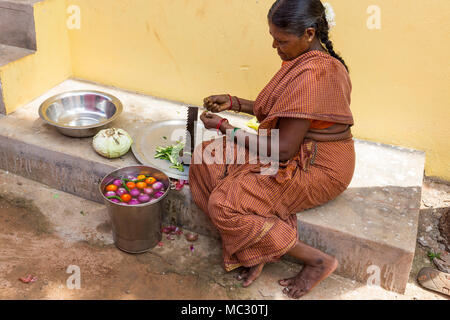 PONDICHERY, PUDUCHERY, INDIA - SEPTEMBER 04, 2017. An unidentified Indian woman cooker in the street, cutting vegetables for lunch. Stock Photo