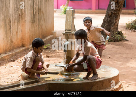 PONDICHERY, PUDUCHERY, INDIA - SEPTEMBER 04, 2017. Unidentified boys girls children clean their plates after lunch at the outdoor canteen. Stock Photo