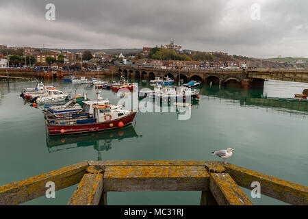 Folkestone, Kent, England, UK - October 29, 2016: Boats in Folkestone Harbour with the old Railway Bridge in the background Stock Photo